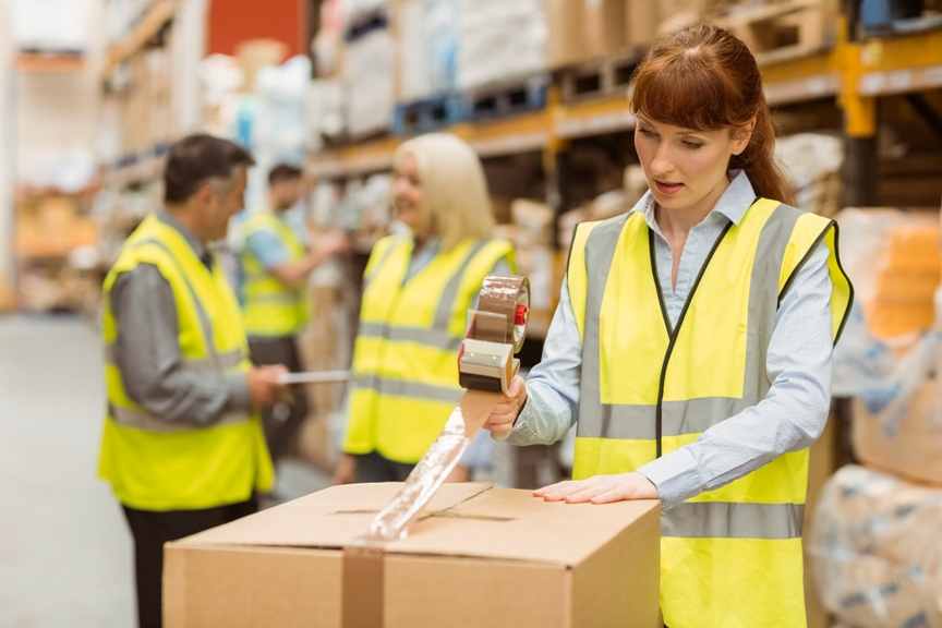Woman working in a warehouse packing a box